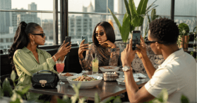 Stylish young Nigerians enjoying soft life culture in Nigeria at a Lagos rooftop café while creating social media content.